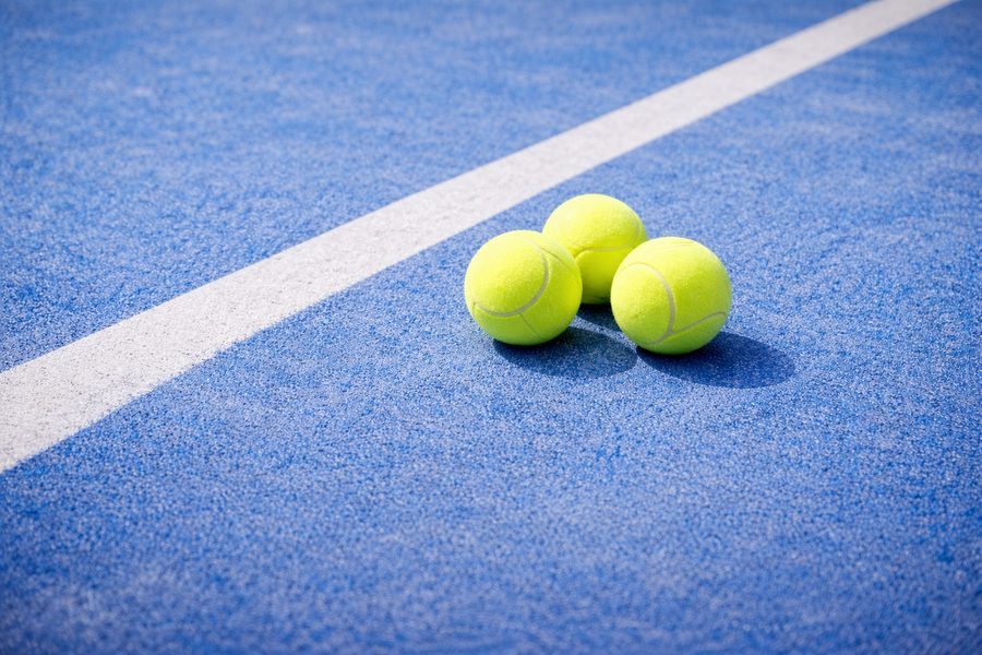 Twee padelspelers in actie op een blauwe padelbaan tijdens een rally