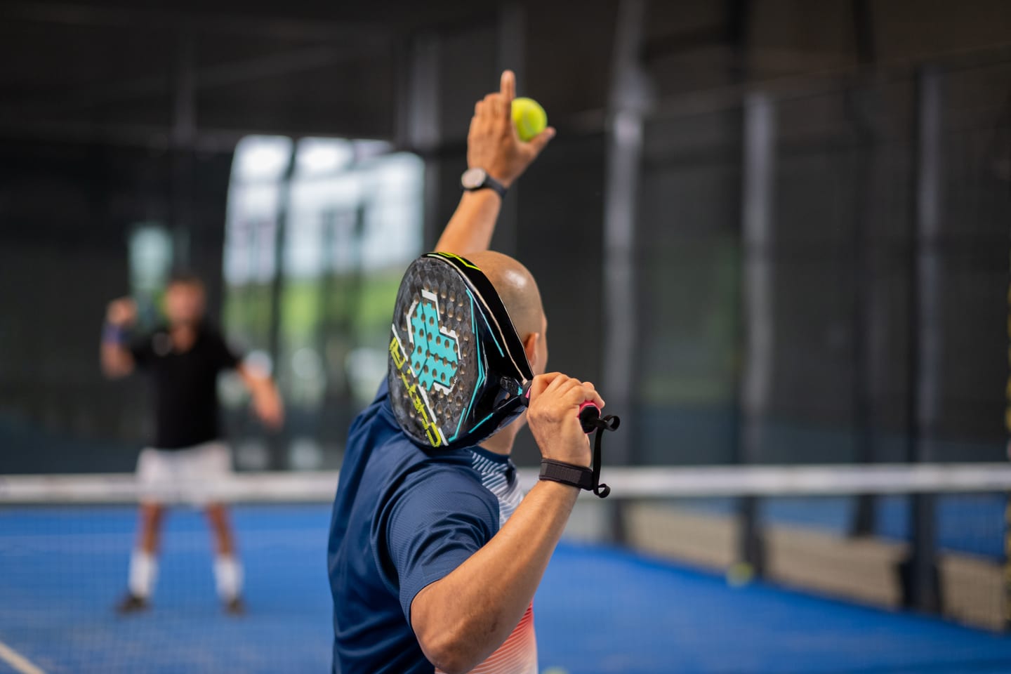 Padelspeler slaat een bajada vanuit de achterhoek naast de wand