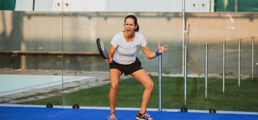 Padelspeler slaat een krachtige drive vanaf de achterlijn