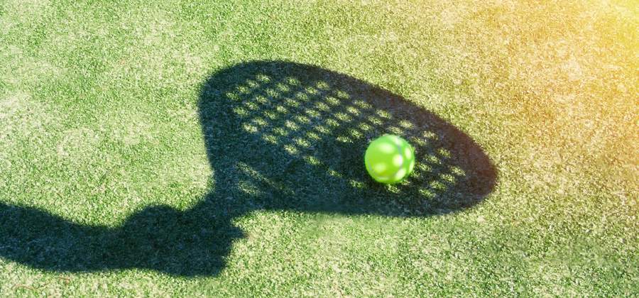 Padelspeler speelt een drop shot met onderdraai net over het net