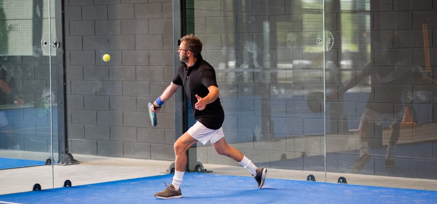 Padelspeler slaat een hoge lob over de tegenstanders heen