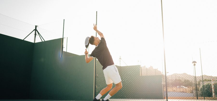 Padelspeler slaat een remate por tres met topspin