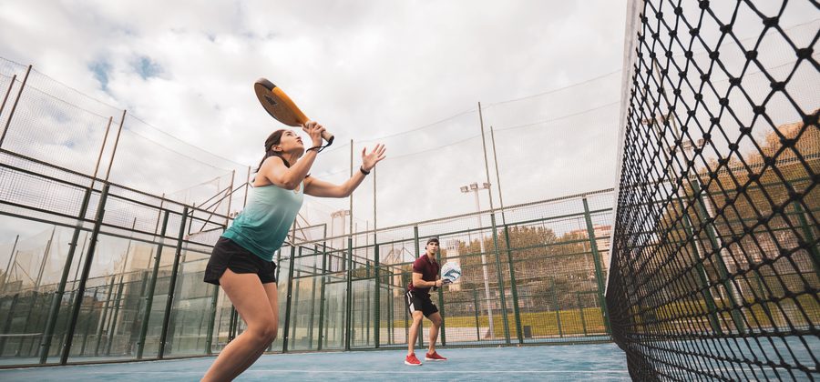 Padelspeler speelt een volea bij het net